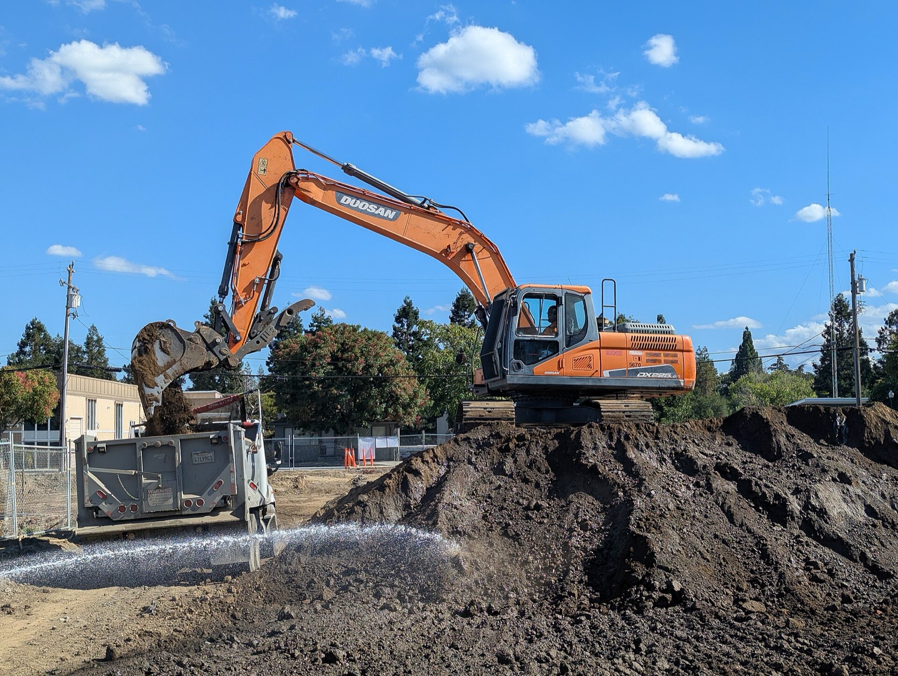 Excavator on a dirt pile at a job site
